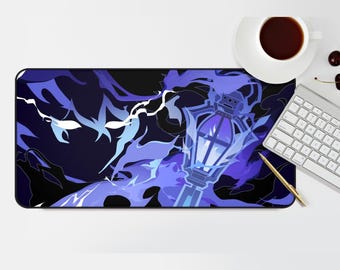 May include: A rectangular mousepad featuring a stylized illustration of a lantern with blue and purple flames against a dark background. A white keyboard, a cup of coffee, and a gold pen are also visible.