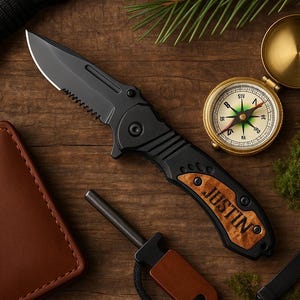 May include: A black pocket knife with a wood handle engraved with the name "JUSTIN". The knife is next to a compass, a fire starter, and a leather wallet.