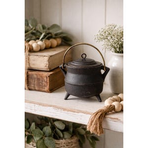 May include: A white ceramic mug with a black handle and the text "But first, coffee" in a handwritten style. The mug is on a white surface. The mug is approximately 4 inches tall.