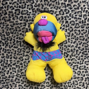 May include: A white ceramic mug with a black handle and the text "But First, Coffee" in a black, handwritten-style font. The mug is on a white surface.