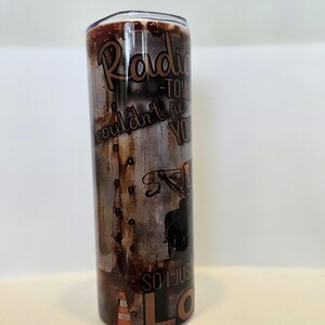 Pode incluir: Caneca de a&ccedil;o inoxid&aacute;vel com um design de metal desgastado. A caneca apresenta o texto "Radio Tow Couldn't Fix You, So I Just Love You" em marrom e branco. Um gr&aacute;fico de reboque e um cone de tr&acirc;nsito laranja tamb&eacute;m s&atilde;o vis&iacute;veis.