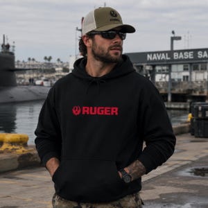 Stay mission‑ready in this Ruger logo hoodie, featuring bold red branding and durable fleece comfort. Ideal for range days, outdoor training, or casual wear. Pairs perfectly with tactical pants, jeans, or boots. A must‑have for gun owners, military supporters, and outdoor enthusiasts who value rugged style and 2A pride.