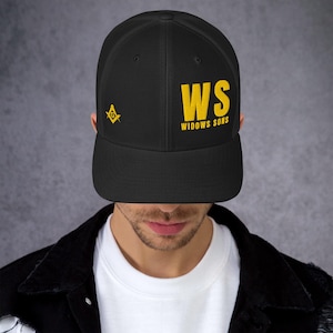 Könnte beinhalten: Schwarze Baseballkappe mit Mesh-Rückseite und gebogenem Schirm. Auf der Kappe steht in gelben Blockbuchstaben "WS WIDOWS SONS", sowie ein kleines gelbes Emblem. Die Kappe wird von einer Person getragen.