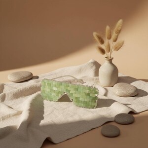 Cooling or warming jade eye mask made from 100% real jade beads. Reduces puffiness, soothes tension, boosts circulation, and brings calm, balance, and radiant renewal.