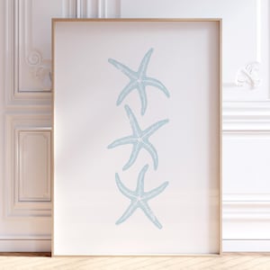 May include: A framed print featuring three light blue starfish arranged vertically on a white background.