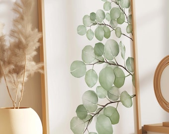 May include: A framed print of a watercolour painting of eucalyptus leaves on a white background. The print is displayed on a wooden shelf with a round mirror and books.