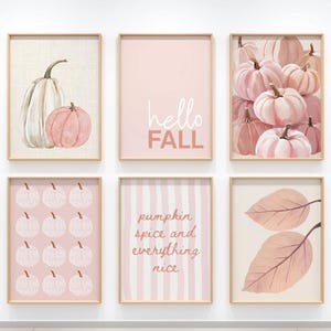 May include: Six framed art prints with a fall theme. The prints feature pumpkins, leaves, and text in shades of pink, white, and beige. One print says "hello FALL", and another says "pumpkin spice and everything nice".