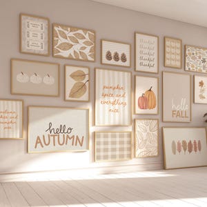 Può includere: Una collezione di stampe artistiche incorniciate con temi autunnali. Le stampe presentano foglie autunnali, zucche e testi come "Hello Autumn" e "Pumpkin Spice". La tavolozza dei colori include tonalità beige, marroni e arancioni, creando un'atmosfera calda.