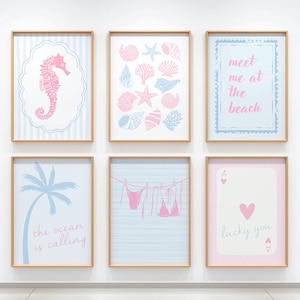 May include: Six framed art prints with beach-themed designs. The prints feature a seahorse, seashells, the text "meet me at the beach", a palm tree with the text "the ocean is calling", a bikini, and a playing card with a heart.