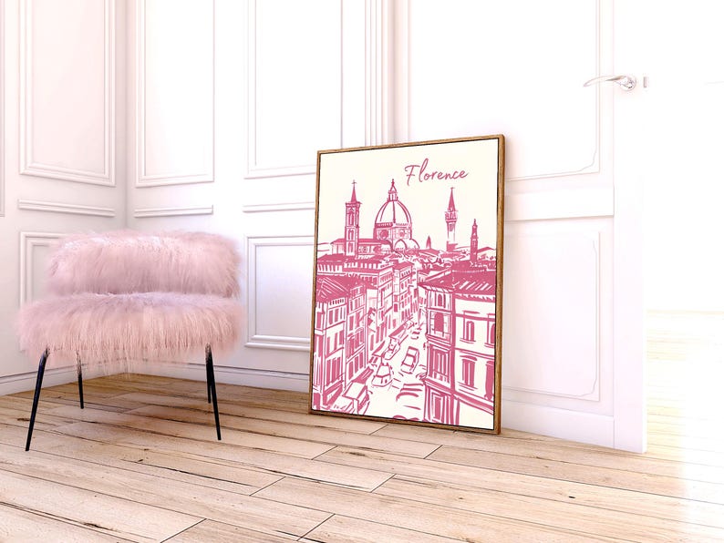 Puede incluir: Una impresi&oacute;n enmarcada de Florencia, Italia, en un estilo de boceto rosa y blanco. La obra de arte presenta la arquitectura de la ciudad, incluido el Duomo. Una silla rosa y esponjosa con patas negras est&aacute; cerca. La impresi&oacute;n est&aacute; apoyada contra una pared blanca.