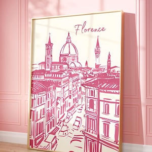 Puede incluir: Una impresi&oacute;n enmarcada con una ilustraci&oacute;n rosa y blanca de Florencia, Italia. La obra de arte representa la arquitectura de la ciudad, incluido el Duomo, con el nombre de la ciudad en escritura cursiva. La impresi&oacute;n se muestra en una pared rosa.