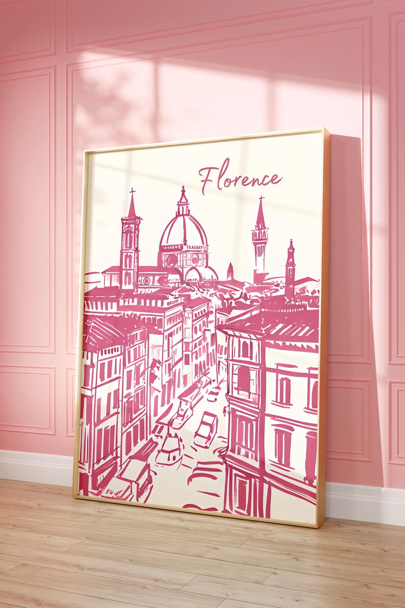 Puede incluir: Una impresi&oacute;n enmarcada con una ilustraci&oacute;n rosa y blanca de Florencia, Italia. La obra de arte representa la arquitectura de la ciudad, incluido el Duomo, con el nombre de la ciudad en escritura cursiva. La impresi&oacute;n se muestra en una pared rosa.