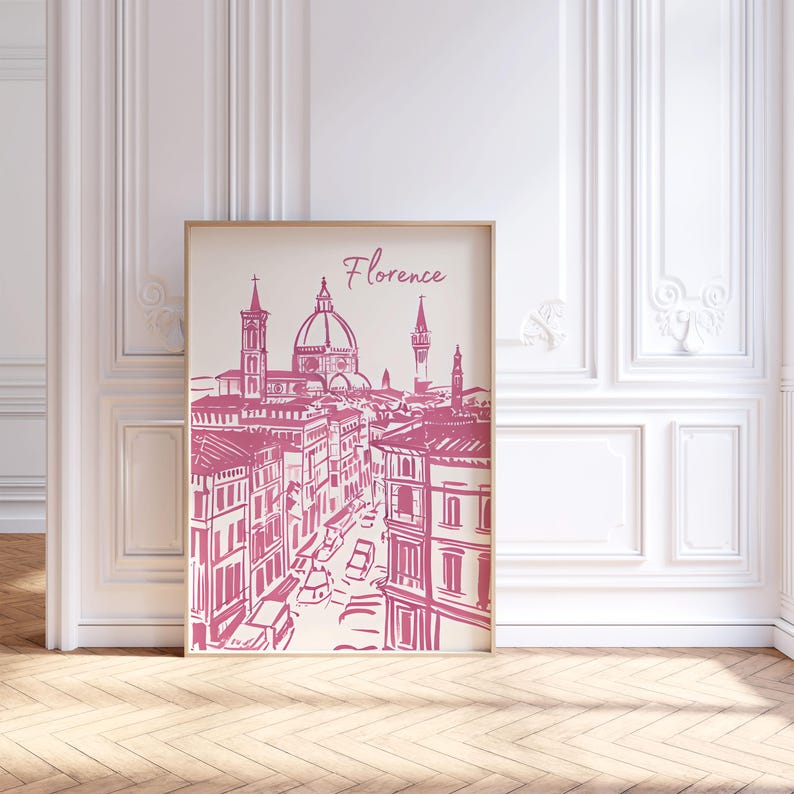 Puede incluir: Una impresi&oacute;n enmarcada con una ilustraci&oacute;n rosa y blanca de Florencia, Italia. La obra de arte representa el horizonte de la ciudad, incluyendo el Duomo y otros edificios. La palabra "Florencia" est&aacute; escrita en cursiva en la parte superior.