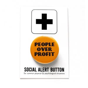 A yellow-orange round pinback button that reads PEOPLE OVER PROFIT in a black art deco font. Button is on a Social Alert Button backing card.