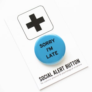 A medium blue pinback button that reads SORRY I'M LATE in plain black text. Pinned to a Social Alert Button branded backing card.