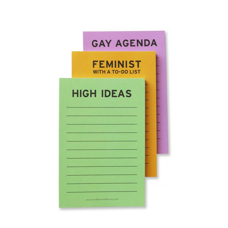 Three vertical rectangle notepads. Top one reads HIGH IDEAS, middle reads FEMINIST WITH A TO-DO LIST. Back pad reads GAY AGENDA at the top, all with check boxes and lines for list making.