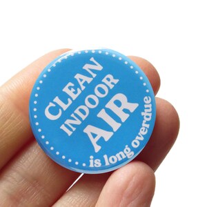 Pode incluir: Um botão azul com texto branco que diz "Clean Indoor Air... is long overdue".