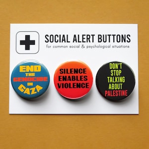 May include: Three circular badges on a white card, featuring bold text. The buttons are in blue, orange, and black, with messages such as "End the Genocide in Gaza" and "Silence Enables Violence". The card also displays a plus symbol and the words "Social Alert Buttons".