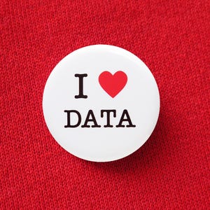 Könnte beinhalten: Weißer Knopf mit rotem Herzen und dem Text "I love DATA" auf rotem Hintergrund.