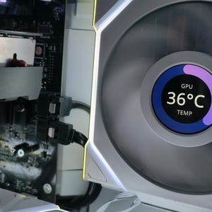 May include: Close-up of a computer fan with a digital display showing "GPU 36°C TEMP". The fan is white and gray with a circular display that has a blue and purple gradient. The computer components are visible in the background.