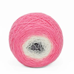 May include: A ball of pink yarn with a gradient effect, transitioning to white and gray in the center. The yarn is tightly wound, suggesting it's ready for knitting or crocheting projects. The color scheme is soft and inviting.