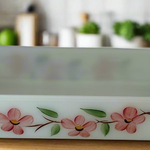 Puede incluir: Fuente rectangular para hornear de estilo vintage en un tono verde pálido. La fuente presenta un diseño floral pintado a mano con flores rosas y hojas verdes. Tiene asas curvas y está hecha de vidrio.