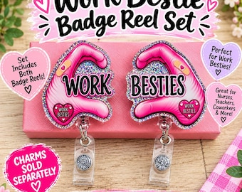 May include: A set of two badge reels featuring pink heart-shaped hand gestures with glittery accents. One reel displays the word WORK and the other displays the word BESTIES in black text. Each reel includes a small pink heart charm with text.
