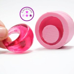 May include: A pink silicone mould for making resin rings. The mould is shown with a finished ring made of clear pink resin.