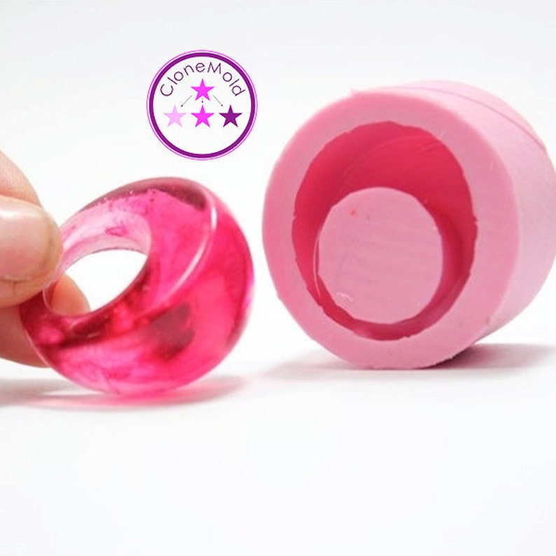 May include: A pink silicone mould for making resin rings. The mould is shown with a finished ring made of clear pink resin.