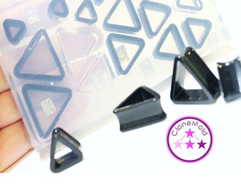 May include: A clear silicone mold with multiple triangle shapes, used for making jewelry.  The mold is filled with black triangle-shaped plugs.  The text "Clone Mold" is visible in the image.