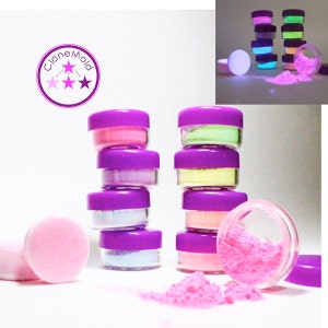 May include: Eight small jars of glow-in-the-dark powder in various colors, including pink, green, yellow, and blue. The jars are stacked in two groups of four. The powder is spilled out of one jar, showing the pink color. The image also includes a logo that says "Clone Mold" with three stars.