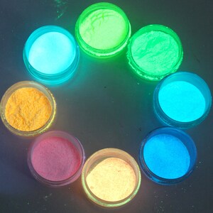 May include: Eight small jars of glow-in-the-dark powder in various colors, including yellow, orange, pink, blue, and green.
