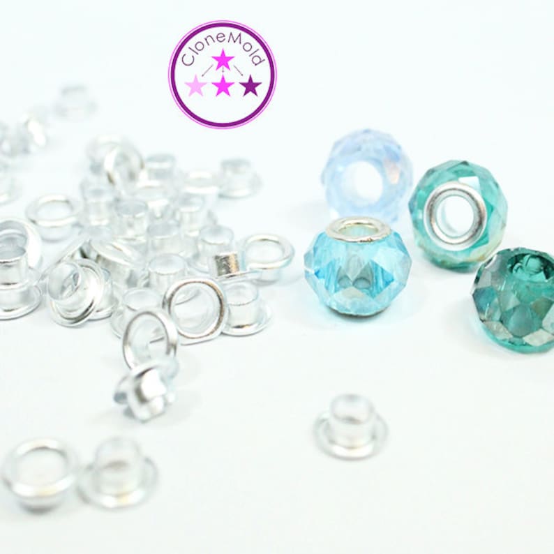 May include: A close-up of silver metal eyelets and three faceted glass beads. The beads are light blue, turquoise, and green. The text "Clone Mold" is visible in the top center of the image.