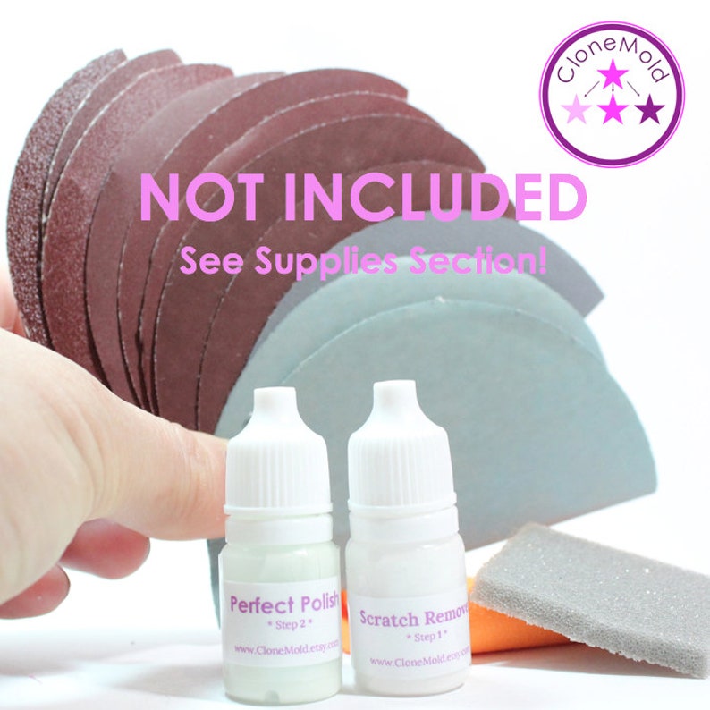 May include: Two small bottles labeled "Perfect Polish" and "Scratch Remover" with instructions for use. The bottles are next to a gray sanding pad and an orange sanding pad. The text "NOT INCLUDED" and "See Supplies Section!" is displayed in pink letters on a white background.