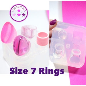 May include: A clear silicone mold for making size 7 rings. The mold has four cavities, including a round, oval, and two square shapes. The mold is shown with pink resin rings.