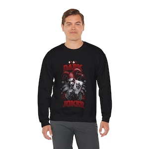 May include: Black sweatshirt featuring a red and white graphic of a joker holding playing cards. The design includes the words "DARK JOKER" in red, with a jester's hat and playing card symbols.