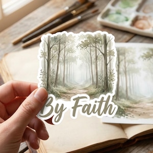May include: A die-cut sticker featuring a watercolor illustration of a misty forest path with tall trees and soft green foliage. The text By Faith is printed in a large, bold, light brown script font across the bottom of the sticker design.