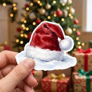May include: A watercolor-style sticker of a red Santa hat with a white fur trim and a white pom-pom. The hat is depicted resting on a soft, white snowy base, featuring deep red shading and textured brushstrokes throughout the fabric.