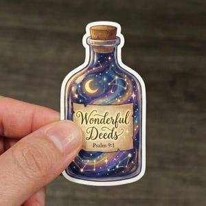 May include: A sticker featuring a bottle with a cork top, filled with a starry night scene. The bottle has a label that reads "Wonderful Deeds" and "Psalm 9:1". The sticker is held by a hand.