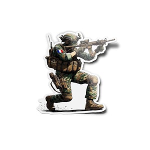 Peut inclure: Un soldat en tenue de camouflage agenouillé et visant un fusil avec une lunette. Le soldat porte un casque et a un patch du drapeau français sur son bras.