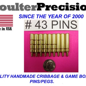 Peut inclure: Un ensemble de 43 pions de cribbage en métal couleur or sur une surface rose. Le texte "#43 PINS" est visible sur une carte blanche.