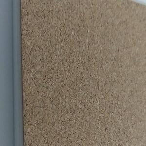 Puede incluir: Un corcho rectangular con borde blanco. El corcho tiene una superficie natural y texturizada, ideal para fijar notas o exhibir objetos. El borde blanco proporciona un borde limpio y acabado.