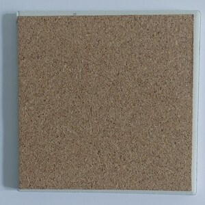 Puede incluir: Posavasos cuadrado de corcho con borde blanco. El posavasos tiene una superficie de corcho texturizado de color marr&oacute;n claro. El borde blanco proporciona un borde limpio al posavasos.