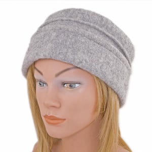 Pu&ograve; includere: Un berretto slouchy di feltro grigio con un bordo ripiegato.
