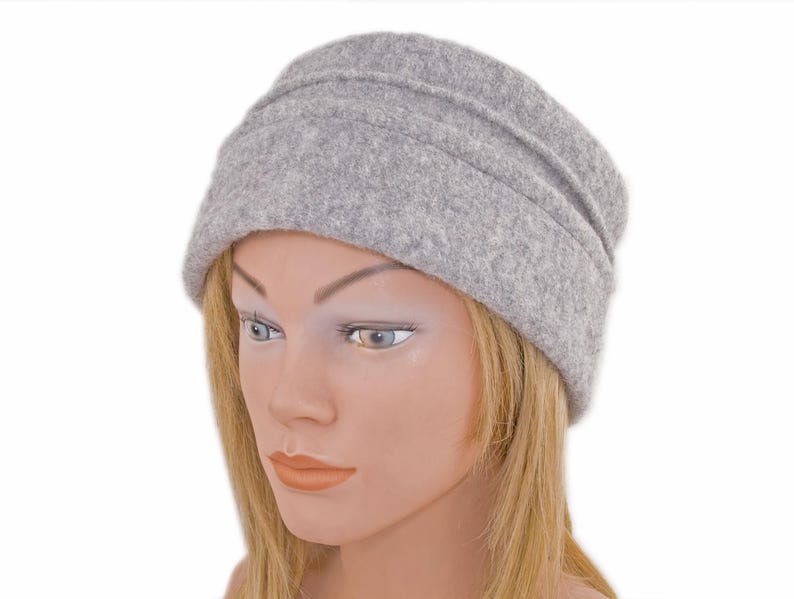 Pu&ograve; includere: Un berretto slouchy di feltro grigio con un bordo ripiegato.