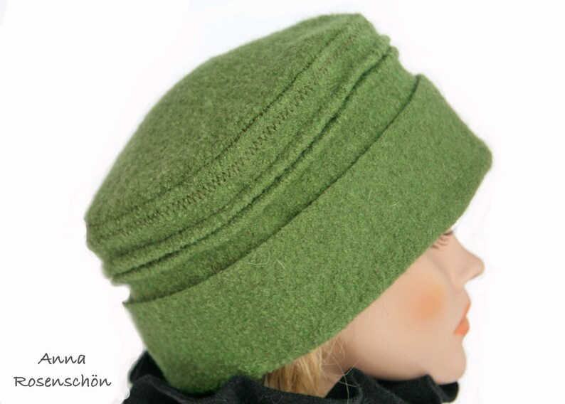 Pu&ograve; includere: Un cappello di lana verde con un bordo ripiegato. Il cappello ha una superficie testurizzata ed &egrave; fatto di un materiale morbido e caldo.