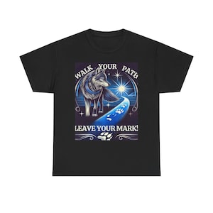May include: Black t-shirt featuring a wolf illustration with the text "WALK YOUR PATH, LEAVE YOUR MARK!". The design includes a wolf, a path with paw prints, and a bright sun.