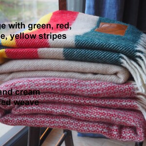 beige throw with green, yellow, red and blue throw and mottled red and cream throw