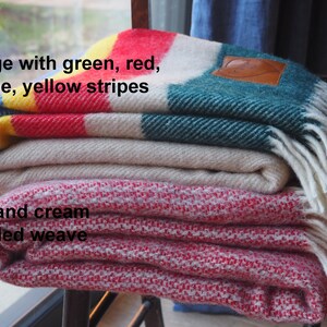 beige throw with green, yellow, red and blue throw and mottled red and cream throw