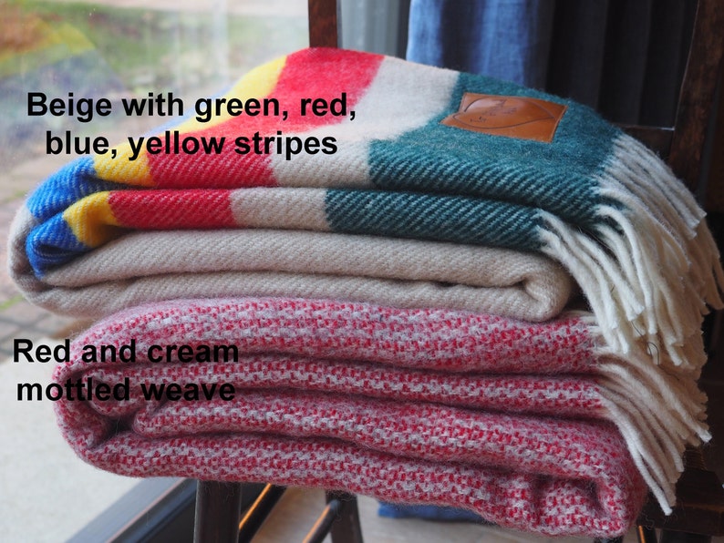 beige throw with green, yellow, red and blue throw and mottled red and cream throw